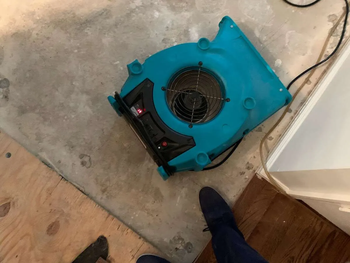 Air mover drying subfloor during Commercial Water Damage Restoration in Paola